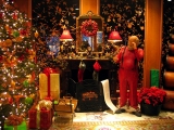 Kerstkaart: Mooi versierde kerstboom met kerstcadeaus voor de open haard in een kamer met belachelijk behang