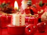 Kerstkaart: Brandende kerstkaars met rode appeltjes en rode kerstpakjes