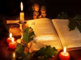 Kerstkaart: Vier kaarsen staan naast de bijbel die opgeslagen ligt bij het kerstevangelie