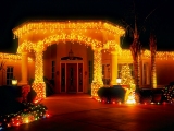 Kerstkaart: De entree van het huis is rijkelijk versierd met kerstverlichting