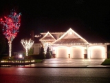 Kerstkaart: Huis dat rijkelijk versierd is met kerstverlichting